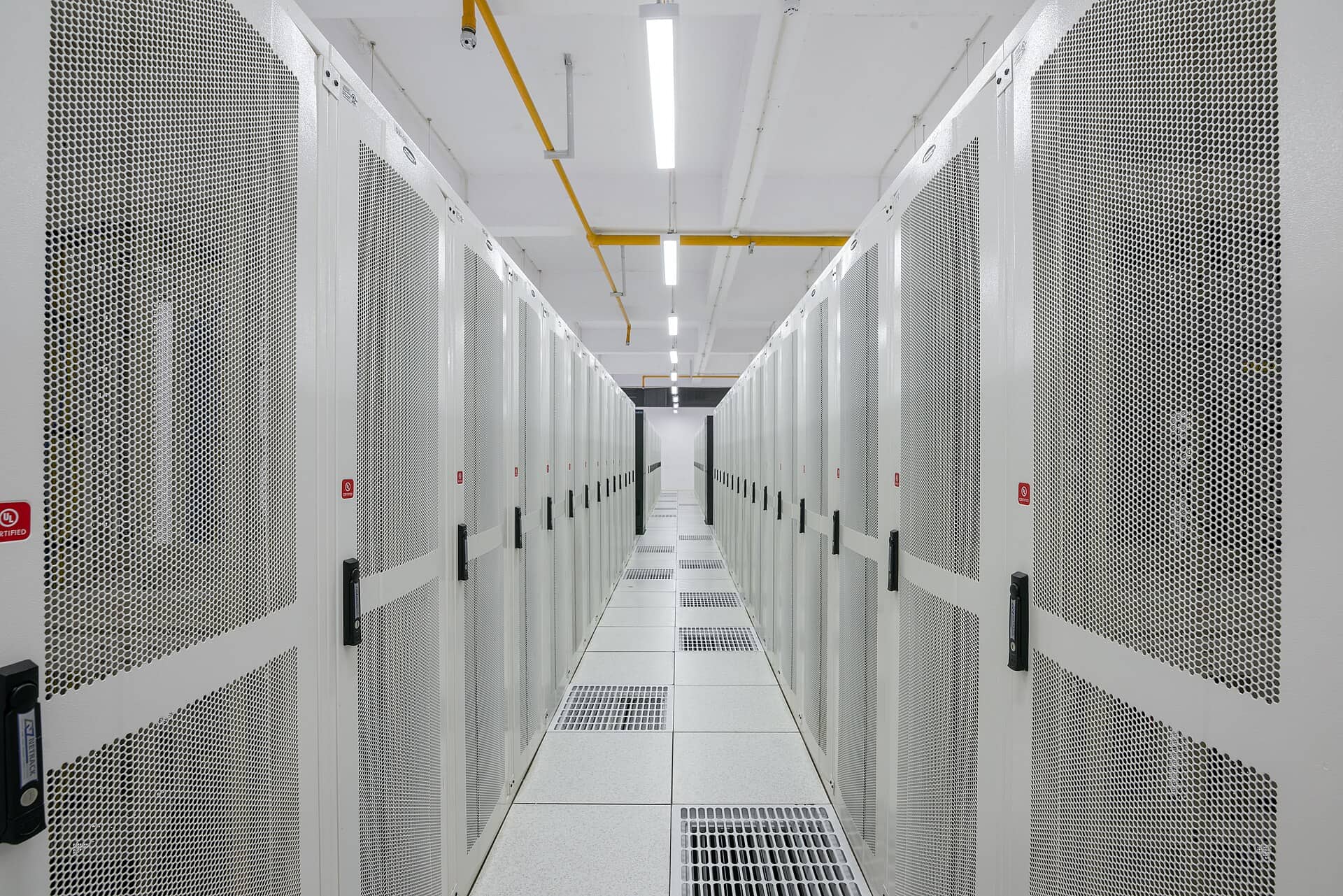 A long aisle between white server racks in a data center in Amravati, India